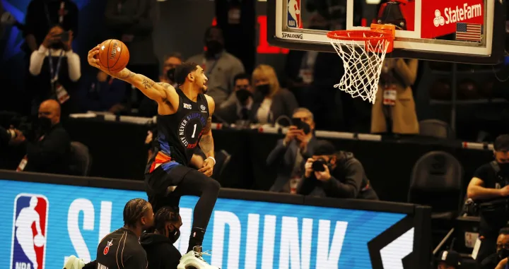epa09060592 Obi Toppin (R) of the New York Knicks leaps over teammate Julias Randle (L) and his father Obadiah Toppin (C) as he performs his final dunk en route to second place in the Slam Dunk Contest during halftime of the NBA All-Star Game at State Farm Arena in Atlanta, Georgia, USA, 07 March 2021. The NBA All-Star game which is traditionally a weekend-long event has been condensed into a single night this year due to the COVID-19 pandemic. EPA/BUTCH DILL SHUTTERSTOCK OUT