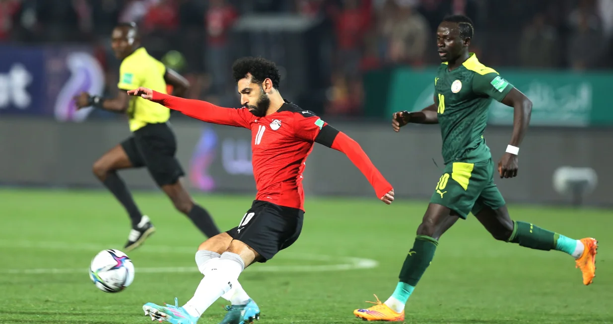 epa09850198 Mohamed Salah (L) of Egypt vies for the ball with Sadio Mane of Senegal during the FIFA Qatar 2022 World Cup Africa qualifiers match between Egypt and Senegal at the International Cairo stadium in Cairo, Egypt, 25 March 2022. EPA/KHALED ELFIQI