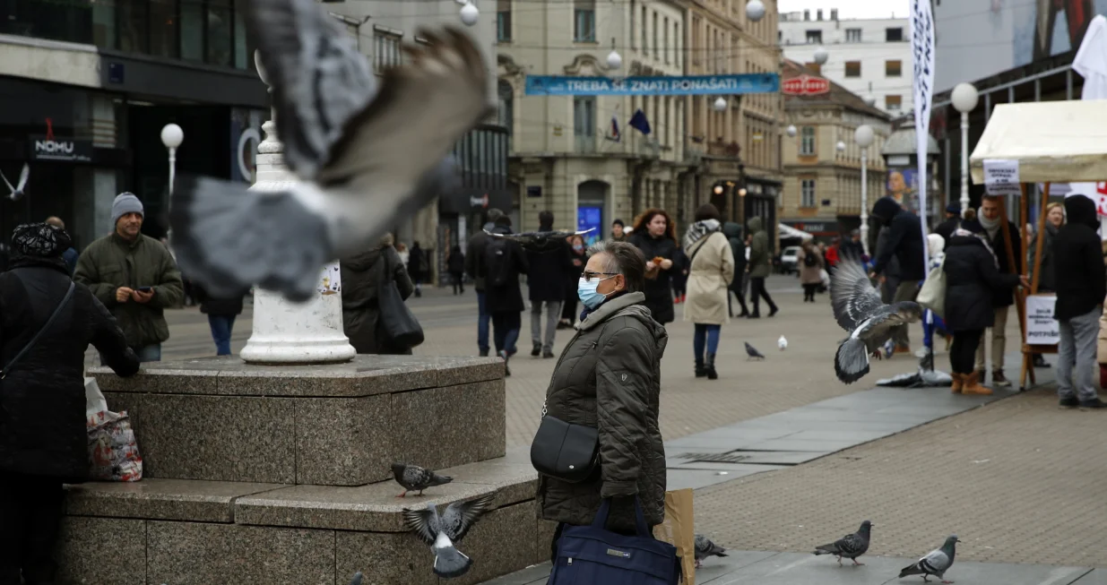 epa09642892 A person wears a face mask while walking around Zagreb, Croatia, 15 December 2021.Croatian authorities have confirmed at least eight people infected with the coronavirus Omicron variant. EPA/ANTONIO BAT/Antonio Bat