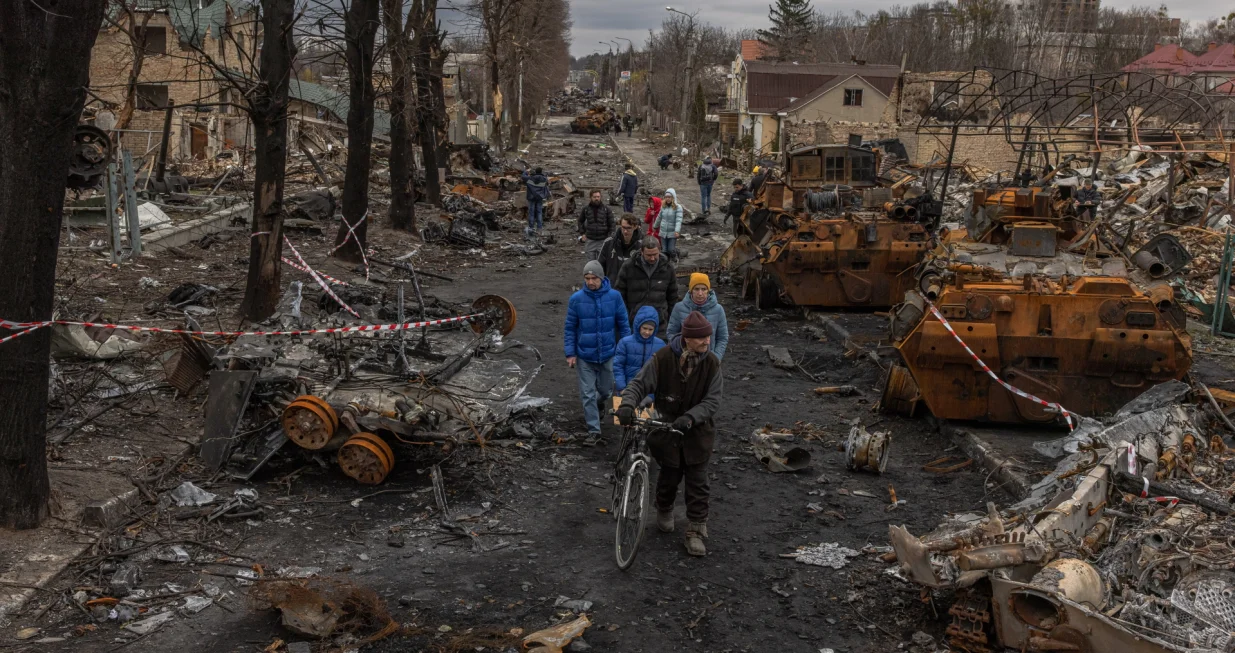 epa10364901 Residents walk past destroyed Russian military machinery on the street, in Bucha, the town which was retaken by the Ukrainian army, northwest of Kyiv, Ukraine, 06 April 2022. EPA/ROMAN PILIPEY/Roman Pilipey