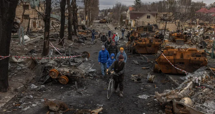 epa10364901 Residents walk past destroyed Russian military machinery on the street, in Bucha, the town which was retaken by the Ukrainian army, northwest of Kyiv, Ukraine, 06 April 2022. EPA/ROMAN PILIPEY/Roman Pilipey