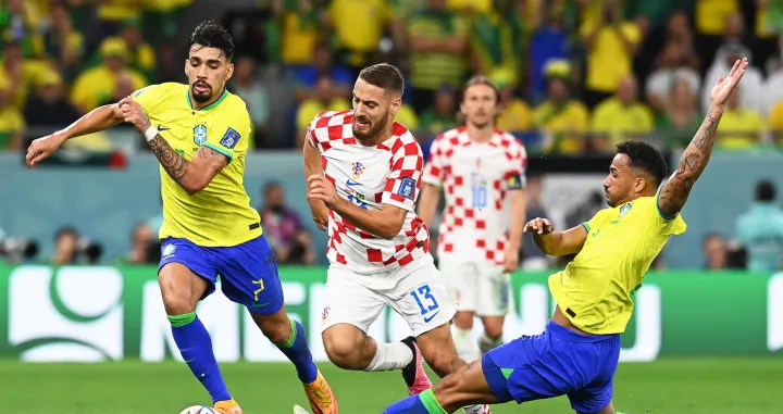 epa10357288 Nikola Vlasic (C) of Croatia in action against Lucas Paqueta (L) of Brazil during the FIFA World Cup 2022 quarter final soccer match between Croatia and Brazil at Education City Stadium in Doha, Qatar, 09 December 2022. EPA/Georgi Licovski