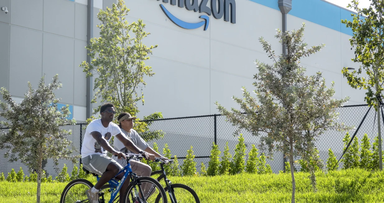 epa10390901 Two persons ride bikes in front of an Amazon logistic center in Miami, Florida, USA, 05 January 2023. According CEO Andy Jassy, Amazon is planning to lay off more than 18,000 employees as part of a workforce reduction. EPA/CRISTOBAL HERRERA-ULASHKEVICH/Cristobal Herrera-ulashkevich
