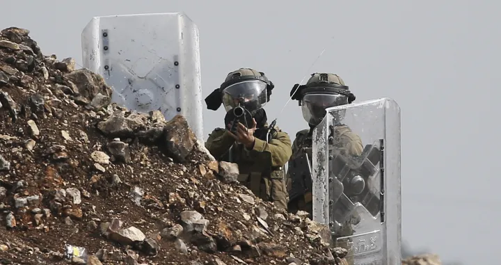 epa10377129 Israeli soldiers react during clashes with Palestinians in Kafr Qaddum village, near the West Bank city of Nablus, 23 December 2022. The clashes followed a protest against Israeli settlements in the area. EPA/ALAA BADARNEH 4277/Alaa Badarneh
