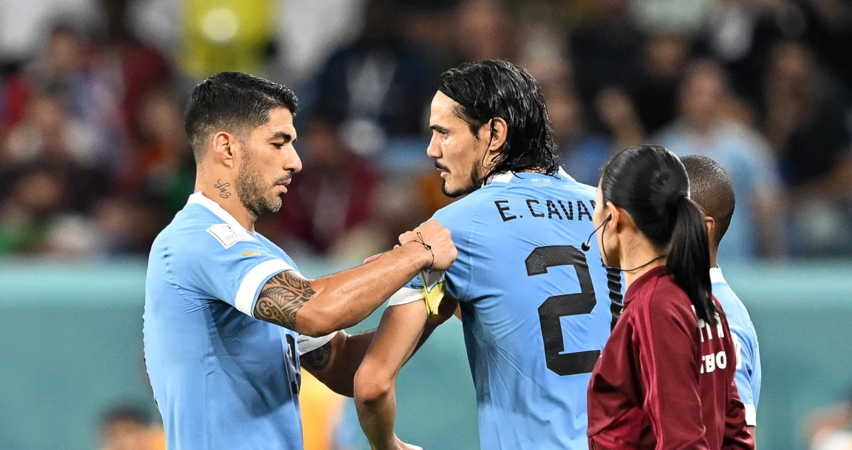 epa10344507 Luis Suarez (L) of Uruguay hands the captain's armband to teammate Edinson Cavani (C) as he leaves the pitch during the FIFA World Cup 2022 group H soccer match between Ghana and Uruguay at Al Janoub Stadium in Al Wakrah, Qatar, 02 December 2022. EPA/Noushad Thekkayil