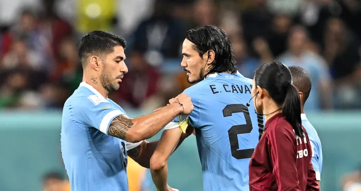 epa10344507 Luis Suarez (L) of Uruguay hands the captain's armband to teammate Edinson Cavani (C) as he leaves the pitch during the FIFA World Cup 2022 group H soccer match between Ghana and Uruguay at Al Janoub Stadium in Al Wakrah, Qatar, 02 December 2022. EPA/Noushad Thekkayil