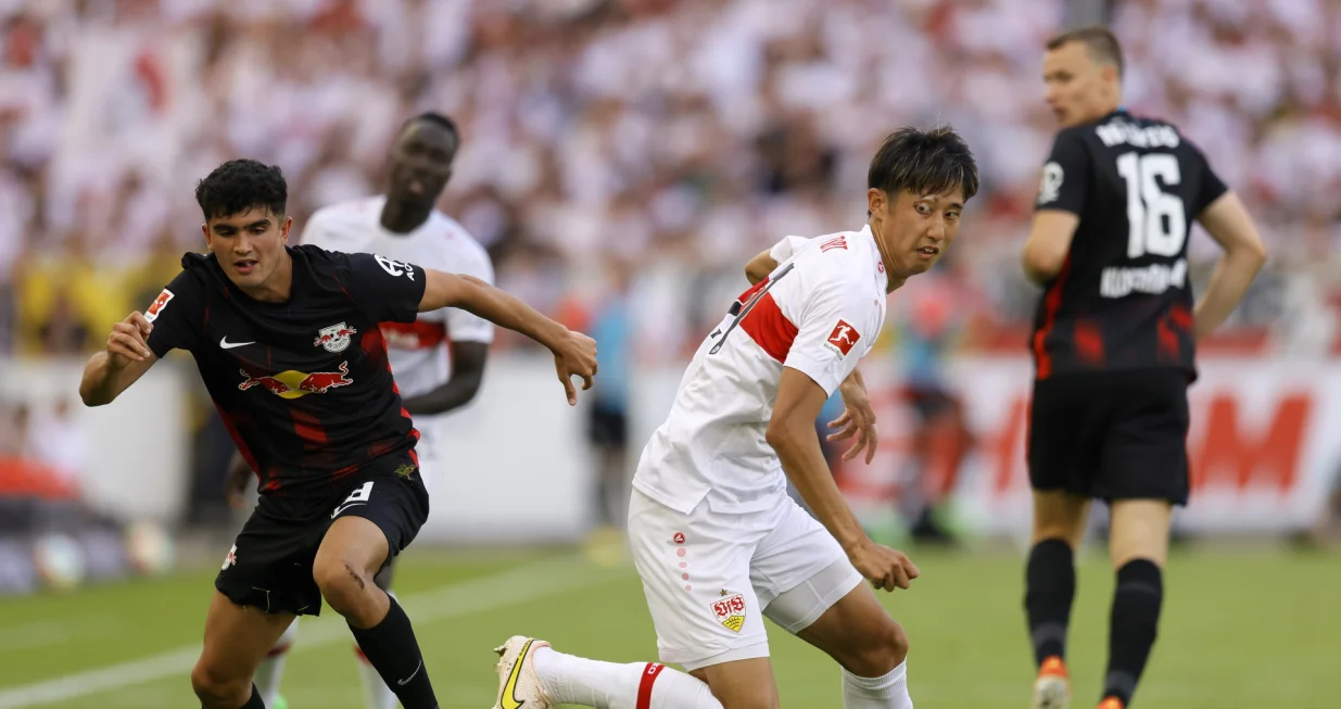 epa10110149 Stuttgart's Hiroki Ito (C) in action against Leipzig's Hugo Novoa (L) during the German Bundesliga soccer match between VfB Stuttgart and RB Leipzig in Stuttgart, Germany, 07 August 2022. EPA/RONALD WITTEK CONDITIONS - ATTENTION: The DFL regulations prohibit any use of photographs as image sequences and/or quasi-video.