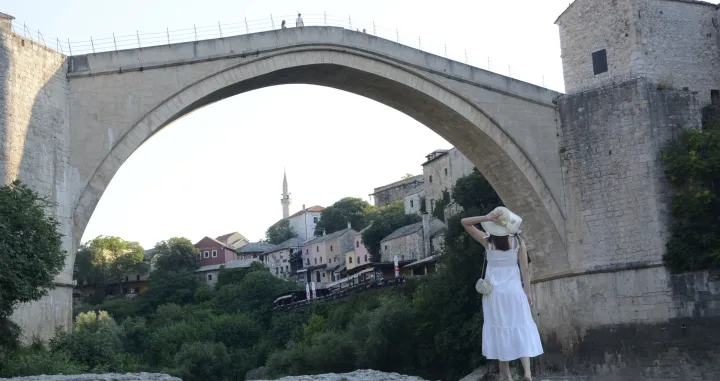 Prošlo je punih 18 godina otkako je prva noga kročila na novi luk obnovljenog Starog mosta. Te prohladne mostarske noći, iako je bio juli, u Mostaru su se okupili državnici iz svijeta i politički vrh Bosne i Hercegovine. Obnova simbola jednog grada i države srušenog tokom agresije na Mostar, trajala je punih šest godina. Finansirali su je Grad Mostar, Svjetska banka, Evropska banka za obnovu i razvoj, te Turkiye, Italija, Hrvatska i Nizozemska. Obnova Starog mosta bila je prekretnica u karijeri tada mlade arhitektice, a danas profesorice Maje Popovac, koja se rado sjeti vremena u kojem je svakodnevno odlazila na most koji se obnavlja. (Željko Milićević - Anadolu Agency)/�