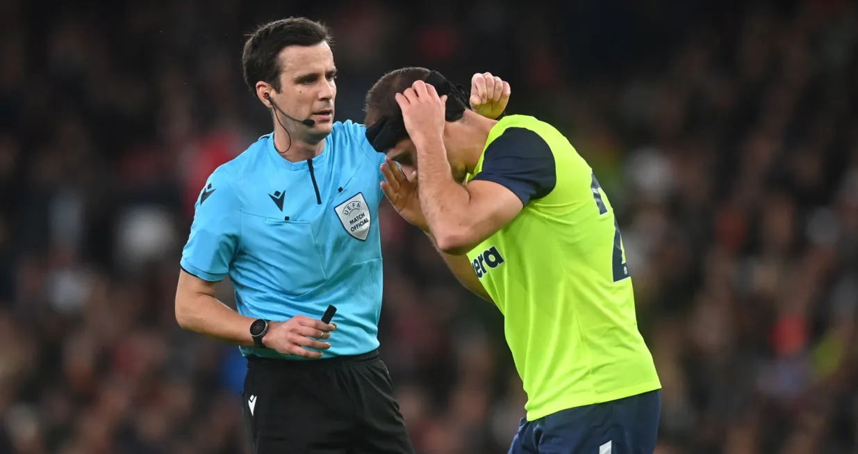 epa10285039 Referee Erik Lambrechts (L) assists FC Zurich's Nikola Katic with his head wear during the UEFA Europa League group stage soccer match between Arsenal and FC Zurich at the Emirates Stadium in London, Britain, 03 November 2022. EPA/NEIL HALL