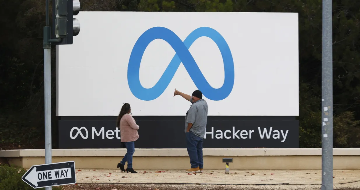 epa10295086 People stand in front of a Meta sign at the headquarters of Meta Platforms Inc., formerly named Facebook, Inc., in Menlo Park, California, USA, 08 November 2022. Chief Executive Mark Zuckerberg told company executives that Meta will begin laying off employees on 09 November. EPA/JOHN G. MABANGLO/John G. Mabanglo