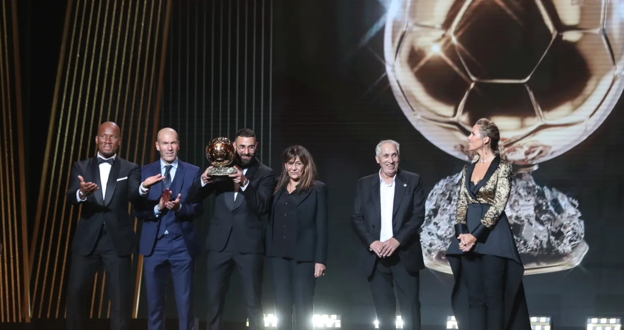 epa10249610 Karim Benzema (3-L) of Real Madrid poses with the Men's Ballon d'Or Trophy next to former Ivorian soccer player Didier Drogba (L), former soccer player Zinedine Zidane (2-L), and Benzema's mother Wahida Djebbara (4-L), during the Ballon d'Or ceremony in Paris, France, 17 October 2022. For the first time the Ballon d'Or, presented by the magazine France Football, will be awarded to the best players of the 2021-22 season instead of the calendar year. EPA/Mohammed Badra