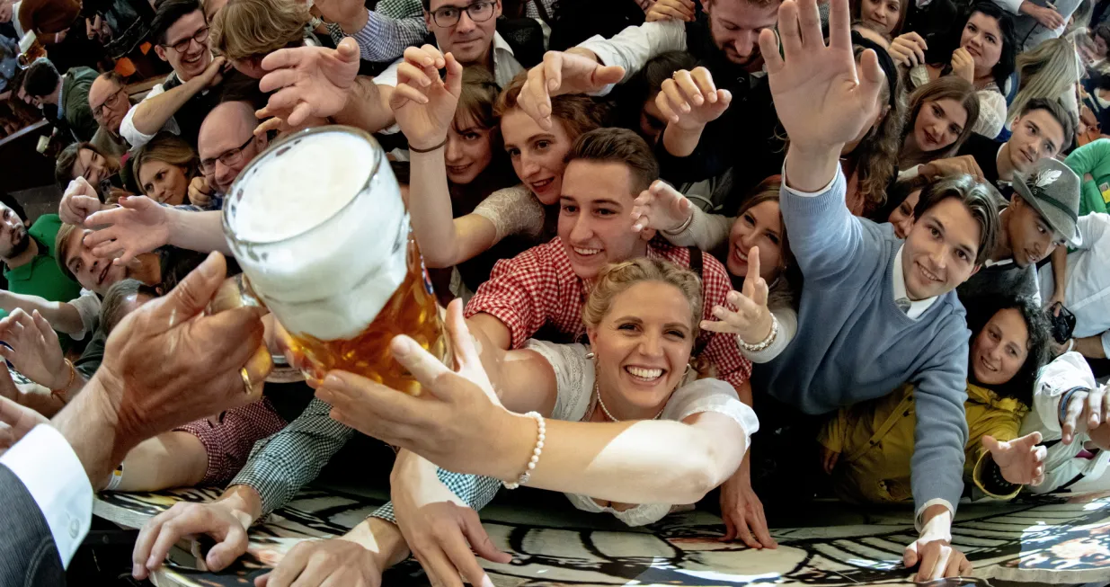 epa10189548 Visitors reach out for free beer in the Paulaner beer tent during the opening of the 187th edition of the traditional Oktoberfest beer and amusement festival in Bavaria's state capital of Munich, Germany, 17 September 2022. The Oktoberfest 2022 runs from 17 September to 03 October 2022 and several millions of visitors are expected from all over the world. The event resumes after being canceled for two years in a row due to the coronavirus disease (COVID-19) pandemic. EPA/CHRISTIAN BRUNA/Christian Bruna