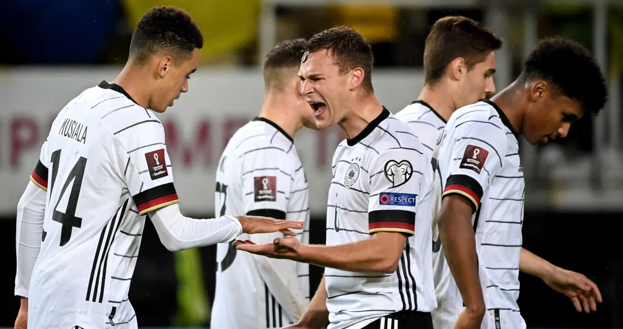 epa09519247 Germany's Jamal Musiala (L) celebrates with his teammate Joshua Kimmich (C) after scoring the 4-0 lead during the FIFA World Cup Qatar 2022 qualifying Group J soccer match between North Macedonia and Germany in Skopje, Republic of North Macedonia, 11 October 2021. EPA/GEORGI LICOVSKI