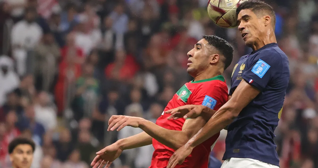 epa10366159 Raphael Varane (R) of France goes for a header during the FIFA World Cup 2022 semi final between France and Morocco at Al Bayt Stadium in Al Khor, Qatar, 14 December 2022. EPA/Friedemann Vogel