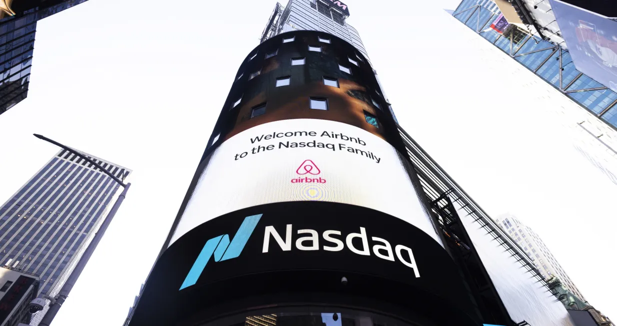 epa08875085 A video screen on the Nasdaq building shows the Airbnb logo to mark the company's initial public offering on the stock exchange in New York, New York, USA, 10 December 2020. Shares of the company after market open were indicated to open at 149 US Dollar per share, more than double the initial price of 68 USD per share. EPA/JUSTIN LANE/Justin Lane