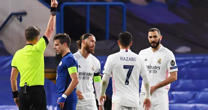 epa09179749 Referee Daniele Orsato (L) shows Sergio Ramos (3-L) of Real Madrid the yellow card during the UEFA Champions League semi final, second leg soccer match between Chelsea FC and Real Madrid in London, Britain, 05 May 2021. EPA/Neil Hall