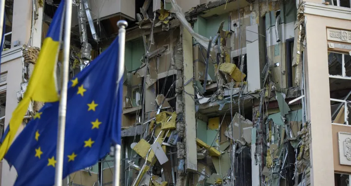 epa10383862 EU and Ukrainian flags fly in front of the damaged hotel building that was hit in a missile strrike in downtown Kyiv (Kiev), Ukraine, 31 December 2022. Russian missiles targeted major cities across Ukraine on 31 December prior to the New Year celebration. Kyiv Mayor Vitaliy Klitschko reported explosions and destruction in three districts of the capital. At least one person was killed, Klitschko said. Russian troops entered Ukraine on 24 February 2022 starting a conflict that has provoked destruction and a humanitarian crisis. EPA/OLEG PETRASYUK/Oleg Petrasyuk