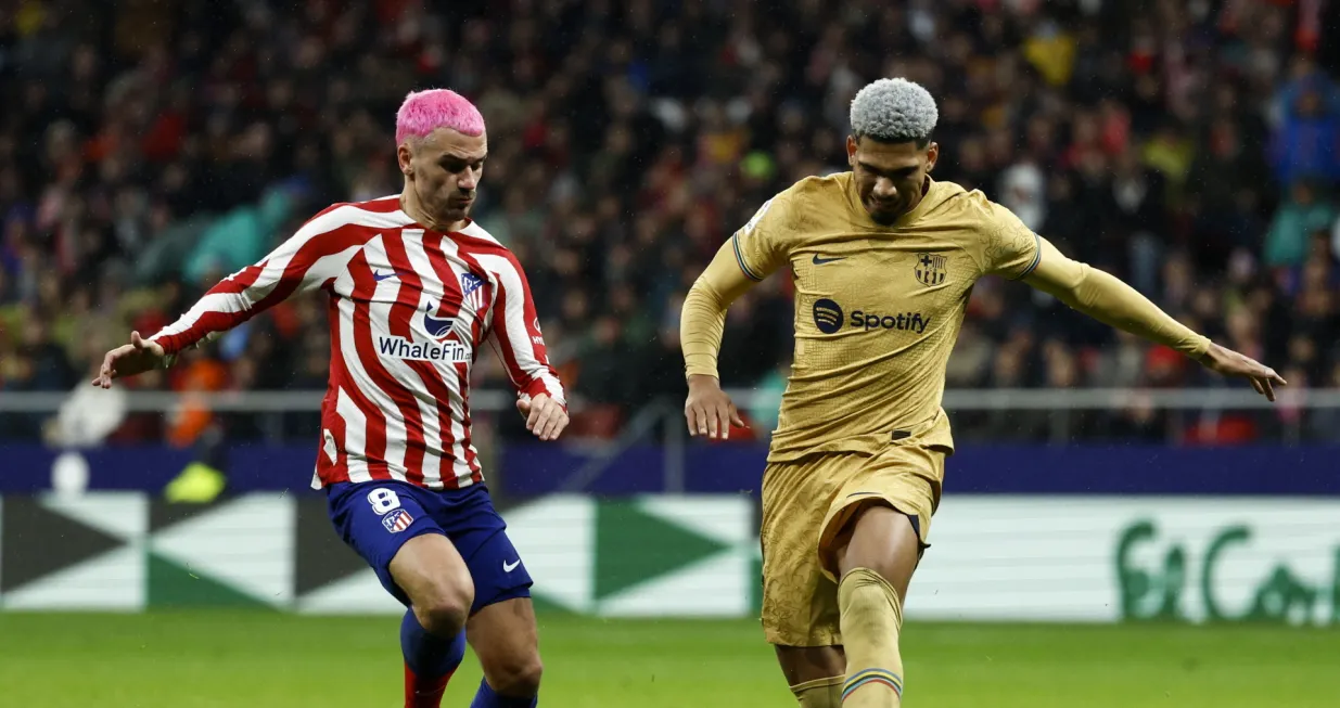 epa10396353 Atletico's striker Antoine Griezmann (L) vies for the ball against FC Barcelona's Uruguayan defender Ronald Araujo (R) during the Spanish LaLiga soccer match between Atletico de Madrid and FC Barcelona at Civitas Metropolitano stadium in Madrid, Spain, 08 January 2023. EPA/Rodrigo Jimenez