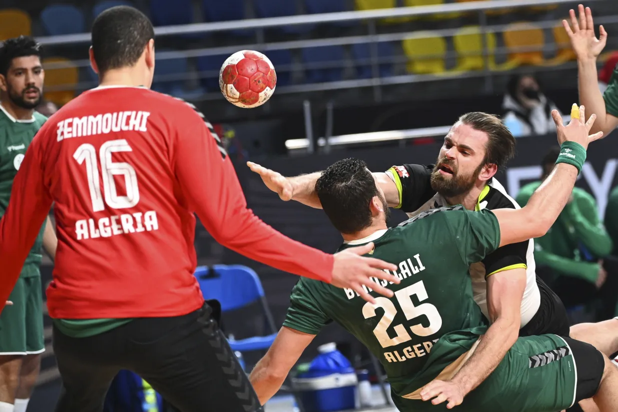 epa08962437 Switzerland's Alen Milosevic (R) in action against Algeria's goalkeeper Yahia Zemouchi (L) and Nouredine Hellal (C) during the Main Round match between Algeria and Switzerland at the 27th Men's Handball World Championship in Giza, Egypt, 24 January 2021. EPA/Anne-Christine Poujoulat/POOL