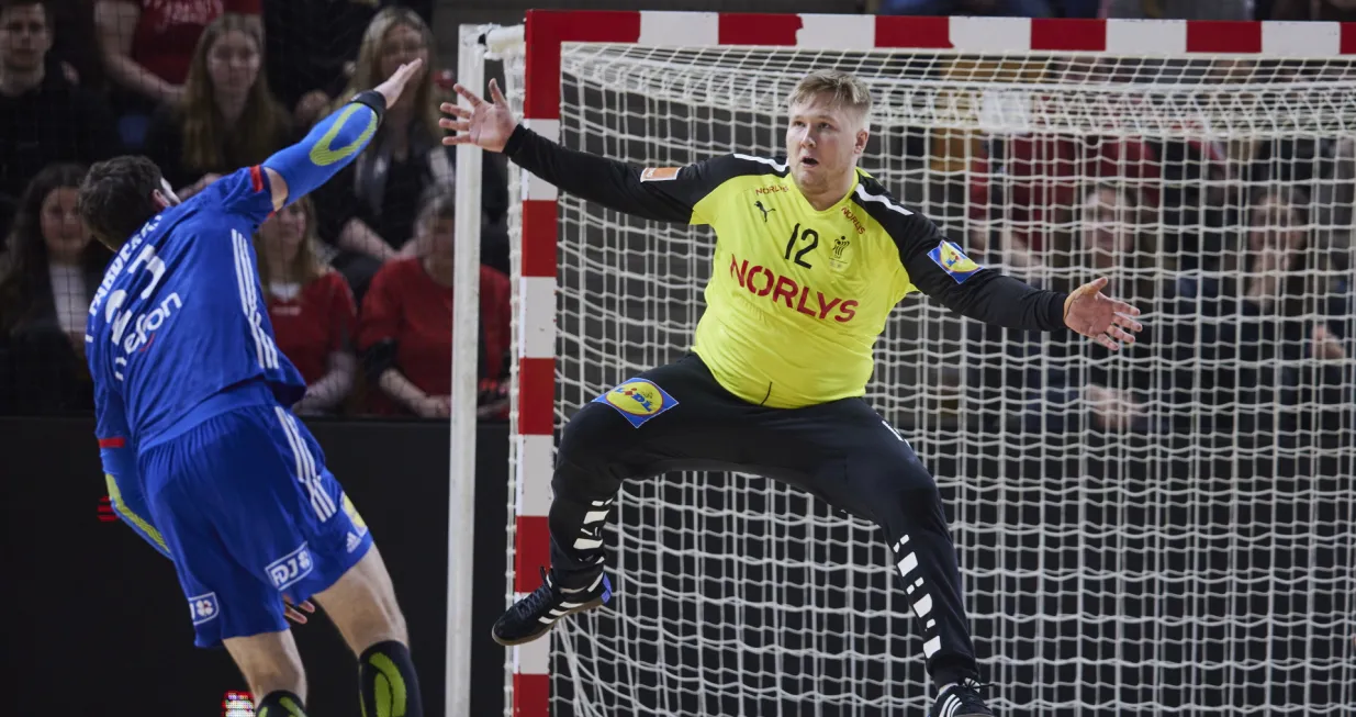 epa09838714 France' Ludovic Fabregas (L) in action against Denmark's goalkeeper Emil Nielsen during the Golden League men's handball match between Denmark and France, in Aarhus, Denmark, 20 March 2022. EPA/Mikkel Berg Pedersen DENMARK OUT