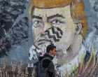 epa08813894 A Palestinian man walks past an anti- USA President Donald Trump mural in the street of Gaza City, 11 November 2020. EPA/MOHAMMED SABER/Mohammed Saber