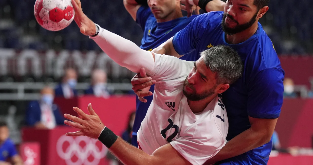 epa09365812 Thiago Ponciano (R) of Brazil and Luka Karabatic of France during the Men's Handball preliminary round group A match between Brazil and France during the Handball events of the Tokyo 2020 Olympic Games at the Yoyogi National Gymnasium arena in Tokyo, Japan, 26 July 2021. EPA/KIMIMASA MAYAMA