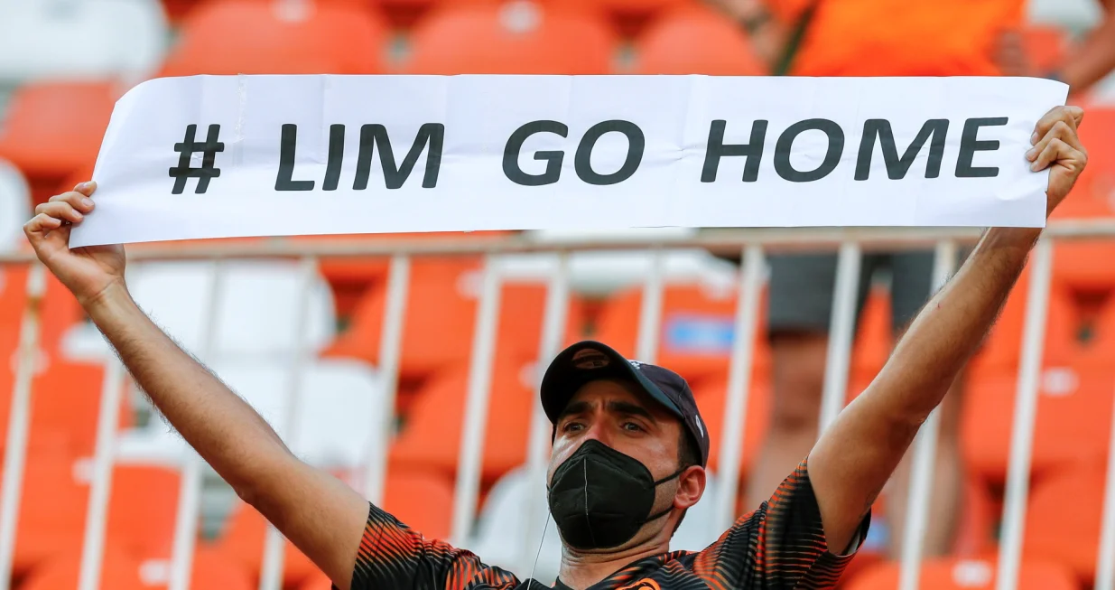 epa09205417 A Valencia's supporter holds a placard that reads 'Lim Go Home' demanding Valencia's owner Peter Lim to leave the club during the Spanish LaLiga soccer match between Valencia CF and SD Eibar held at Mestalla stadium in Valencia, eastern Spain, 16 May 2021. EPA/Biel Alino