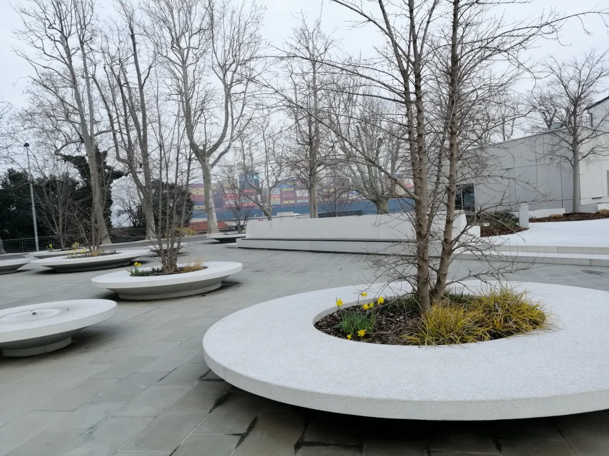 Kopar: Žardinjere s drvećem i trajnicama, a okolo klupa za odmor/