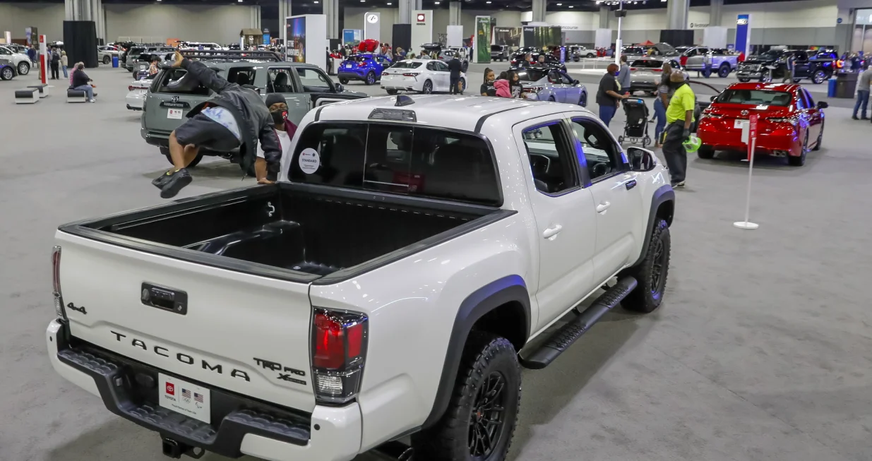 epa09142257 A boy jumps from the bed of a 2021 Toyota Tacoma pickup truck on display during the Atlanta International Auto Show at the Georgia World Congress Center in Atlanta, Georgia, USA, 17 April 2021. The show, whose roots date back to 1909, is one of the few in-person auto shows in operation due to the COVID-19 coronavirus pandemic. EPA/ERIK S. LESSER/Erik S. Lesser