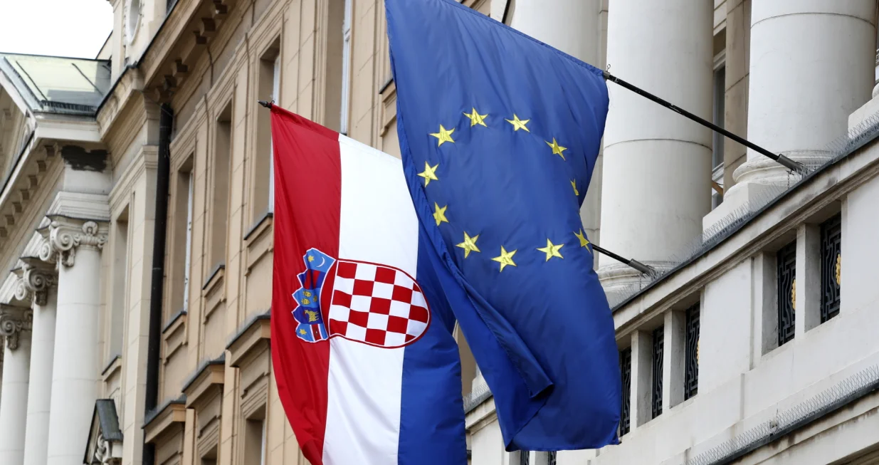 epa09960504 The flags of Croatia (L) and European Union (EU) hang from the facade of the Parliament building at old town in Zagreb, Croatia, 20 May 2022. Croatia, which joined the EU in 2013, is set to join the Eurozone in January 2023, with the introduction of the euro as the country's official currency after Croatian lawmakers voted in favor of legislation to bring the shared currency. EPA/ANTONIO BAT/Antonio Bat