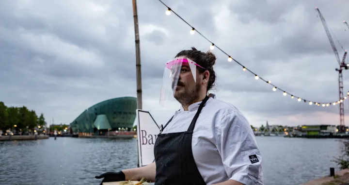 Otvaraju se kafići, restorani, frizerski saloni i druge uslužne djelatnosti koje su bile zatvorene oko dva mjeseca. Uz otvaranje objekata dolaze i mjere zaštite koje propisuju vlade i koje su različite od zemlje do zemlje. U Amsterdamu u jednom restoranu konobari koji nose vizire i rukavice poslužuju goste.Naime, izvan zatvorenog dijela restorana napravljena je staklena bašta, nekoliko manjih staklenih objekata, u kojima mogu sjediti maksimalno tri osobe. (Paco Núñez - Anadolu Agency)/Paco Núñez