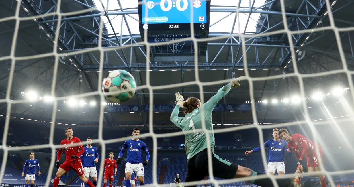 epa08962408 Thomas Muller (R) of Bayern Munich scores their sides first goal past Ralf Fahrmann of FC Schalke 04 during the German Bundesliga soccer match between FC Schalke 04 and FC Bayern Munich at Veltins-Arena in Gelsenkirchen, Germany, 24 January 2021. EPA/LARS BARON/POOL DFL regulations prohibit any use of photographs as image sequences and/or quasi-video.