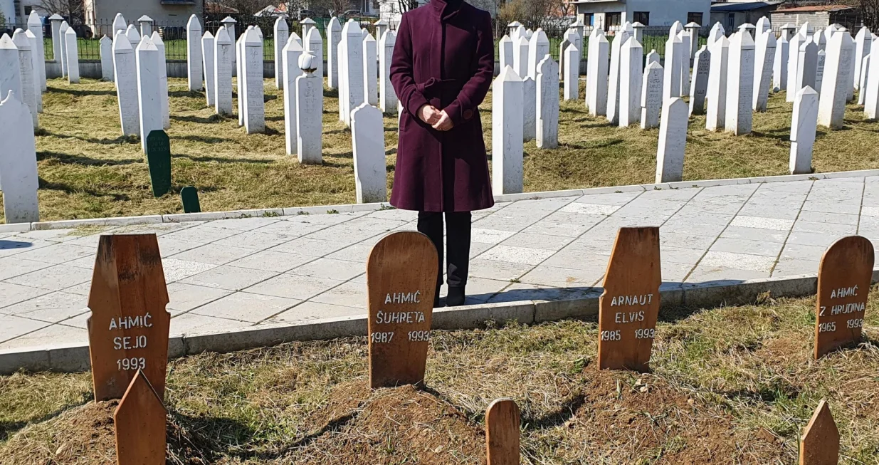 Enisa Ahmić Mulić na šehidskom mezarju u Vitezu 2021. godine, pored ukopanih amidže, strine i njihovo troje djece, među kojima je i tromjesečna beba Sejo/