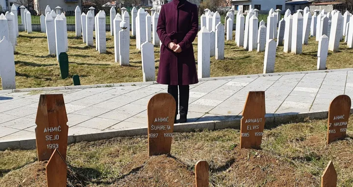 Enisa Ahmić Mulić na šehidskom mezarju u Vitezu 2021. godine, pored ukopanih amidže, strine i njihovo troje djece, među kojima je i tromjesečna beba Sejo/