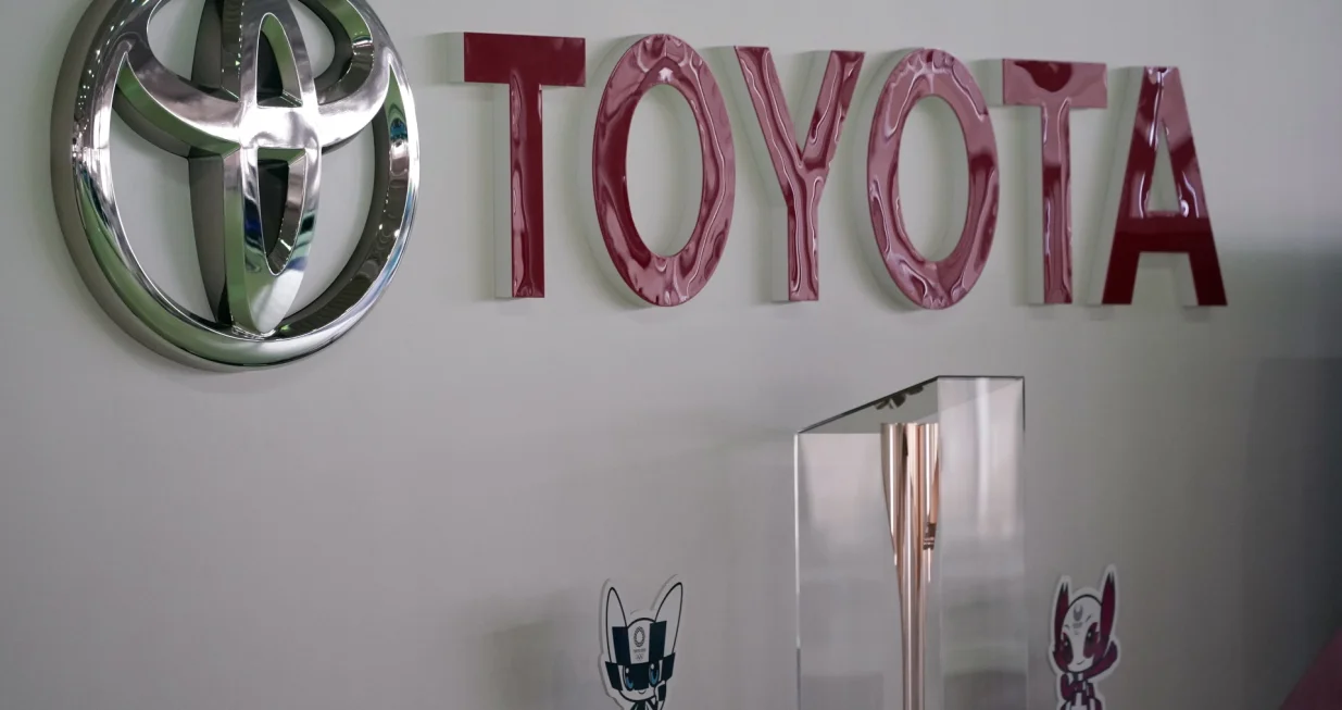 epa09192981 The Tokyo 2020 Olympic and Paralympic Games mascots and a torch are displayed under a Toyota logo at a showroom in Tokyo, Japan, 12 May 2021. Toyota Motor Corp. announced that for the fiscal year ended March 2021, the car maker's consolidated vehicle unit sales in Japan and overseas decreased by 14.6 percent year-on-year amid the COVID-19 pandemic. EPA/FRANCK ROBICHON/Franck Robichon