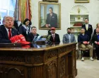 U.S. President Donald Trump speaks next to wounded veterans as he signs executive orders in the Oval Office at the White House in Washington, D.C., U.S., April 23, 2025. REUTERS/Leah Millis/Leah Millis