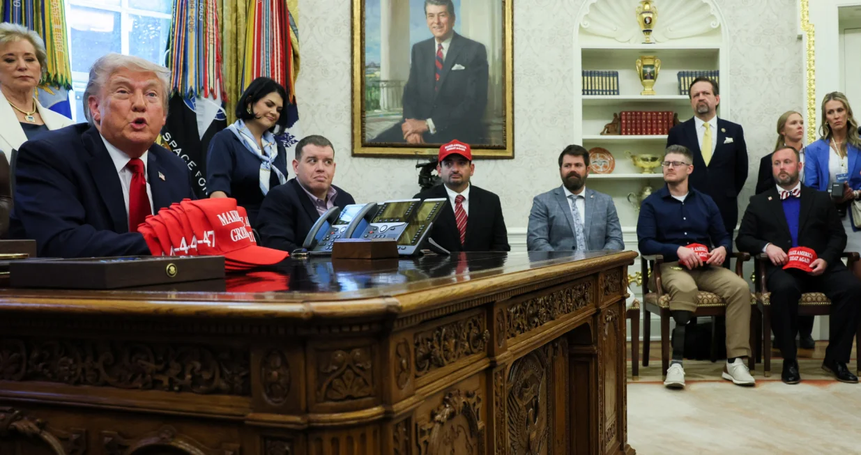 U.S. President Donald Trump speaks next to wounded veterans as he signs executive orders in the Oval Office at the White House in Washington, D.C., U.S., April 23, 2025. REUTERS/Leah Millis/Leah Millis