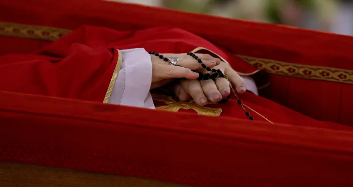 A rosary is seen as the body of Pope Francis is placed in an open casket during the rite of the declaration of death in Santa Marta residence at the Vatican, April 21, 2025. Vatican Media/­Handout via REUTERS ATTENTION EDITORS - THIS IMAGE WAS PROVIDED BY A THIRD PARTY. TPX IMAGES OF THE DAY REFILE - CORRECTING DATE/Simone Risoluti
