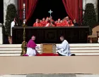 Clergy members kneel by the coffin of Pope Francis during his funeral Mass in St. Peter's Square at the Vatican, April 26, 2025. REUTERS/Guglielmo Mangiapane/Guglielmo Mangiapane