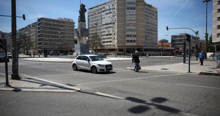A person walks on a crosswalk as a car passes by during a power outage in Lisbon, Portugal April 28, 2025. REUTERS/Pedro Nunes/Pedro Nunes