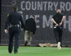 Apr 30, 2025; Pittsburgh, Pennsylvania, USA; Stadium security and Pittsburgh Pirates medical personnel rush to assist a fan who fell from the stands to the field as the Pirates batted against the Chicago Cubs during the seventh inning at PNC Park. Mandatory Credit: Charles LeClaire-Imagn Images