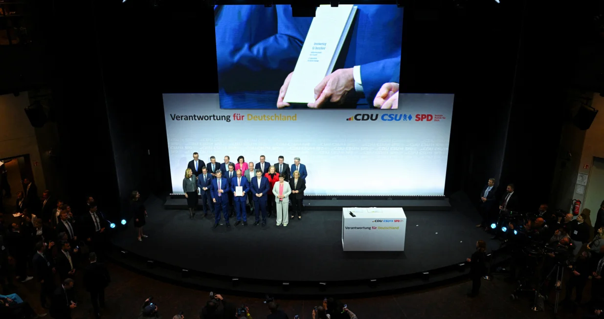 Incoming German Chancellor and leader of the Christian Democratic Union (CDU) Friedrich Merz holds the coalition government agreement between CDU, CSU and SPD, next to Christian Social Union (CSU) leader and Bavarian Premier Markus Soeder and Designated German Vice Chancellor and Designated Finance Minister Lars Klingbeil, at the Gasometer in Berlin, Germany May 5, 2025. REUTERS/Annegret Hilse/Annegret Hilse