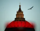 A bird flies past the dome of St. Peter's Basilica on the first day of the conclave to elect the next pope, near the Vatican, in Rome, Italy, May 7, 2025. REUTERS/Guglielmo Mangiapane  TPX IMAGES OF THE DAY/Guglielmo Mangiapane
