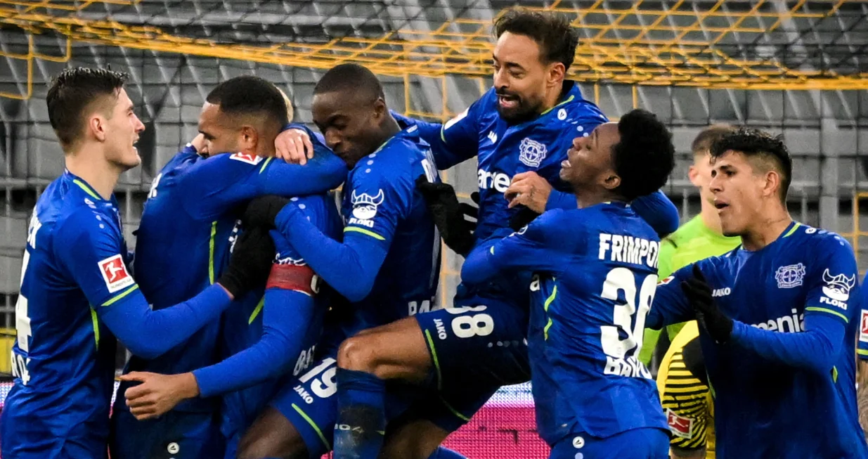 epa09733178 Leverkusen's Jonathan Tah (3-L) celebrates with teammates after scoring the 4-1 lead during the German Bundesliga soccer match between Borussia Dortmund and Bayer Leverkusen in Dortmund, Germany, 06 February 2022. EPA/SASCHA STEINBACH CONDITIONS - ATTENTION: The DFL regulations prohibit any use of photographs as image sequences and/or quasi-video.