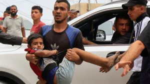 A Palestinian man carries a wounded person to Nasser hospital following an Israeli strike, in Khan Younis, southern Gaza Strip, May 15, 2025. REUTERS/Hatem Khaled/Hatem Khaled