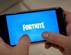 epa08621882 A person plays Fortnite on an iPhone in Miami, Florida, USA, 24 August 2020. US tech giant Apple and game developer Epic Games are in a dispute over the distribution of income from in-app purchases of the game Fortnite. EPA/CRISTOBAL HERRERA-ULASHKEVICH/Cristobal Herrera-ulashkevich