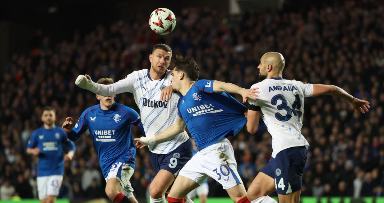 Soccer Football - Europa League - Round of 16 - Second Leg - Rangers v Fenerbahce - Ibrox, Glasgow, Scotland, Britain - March 13, 2025 Fenerbahce's Edin Dzeko in action with Rangers' Ianis Hagi REUTERS/Russell Cheyne
