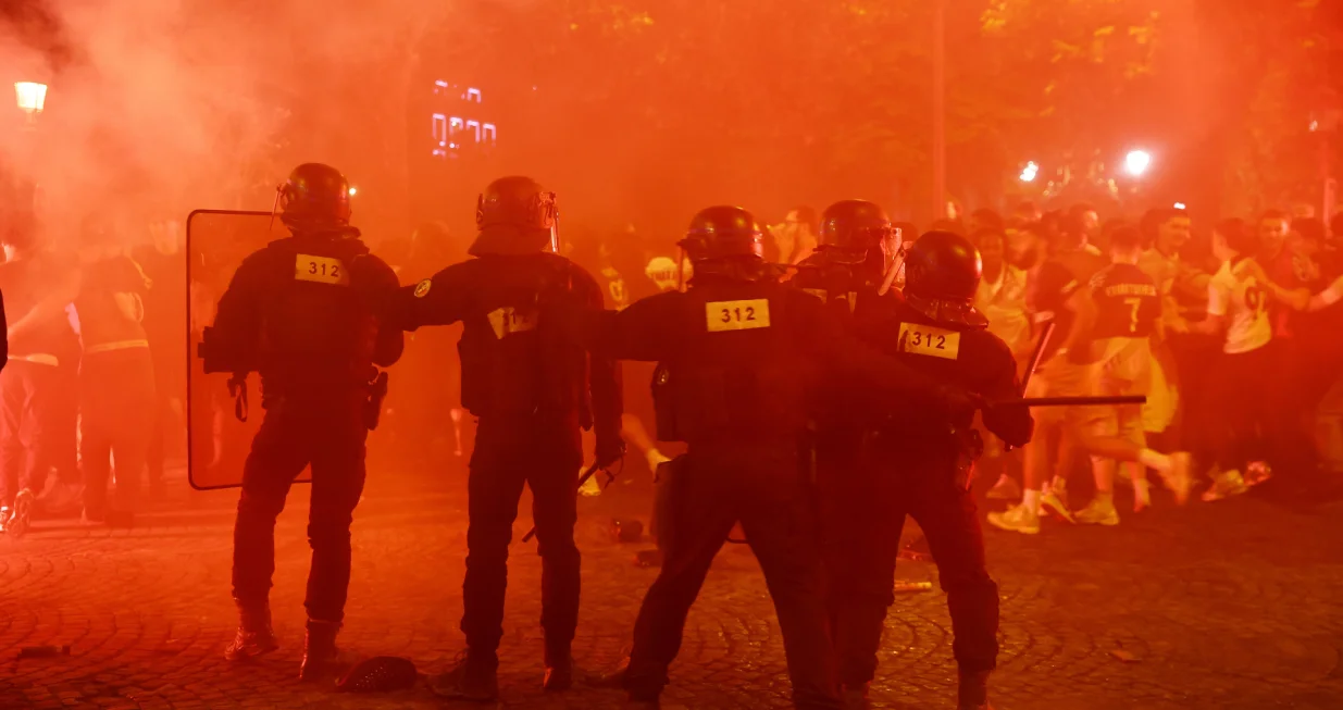 Soccer Football - Champions League - Final - Paris St Germain fans gather in Paris - Paris, France - May 31, 2025 Riot police protect themselves from fans on the Champs Elysees avenue after Paris St Germain won the Champions League REUTERS/Abdul Saboor
