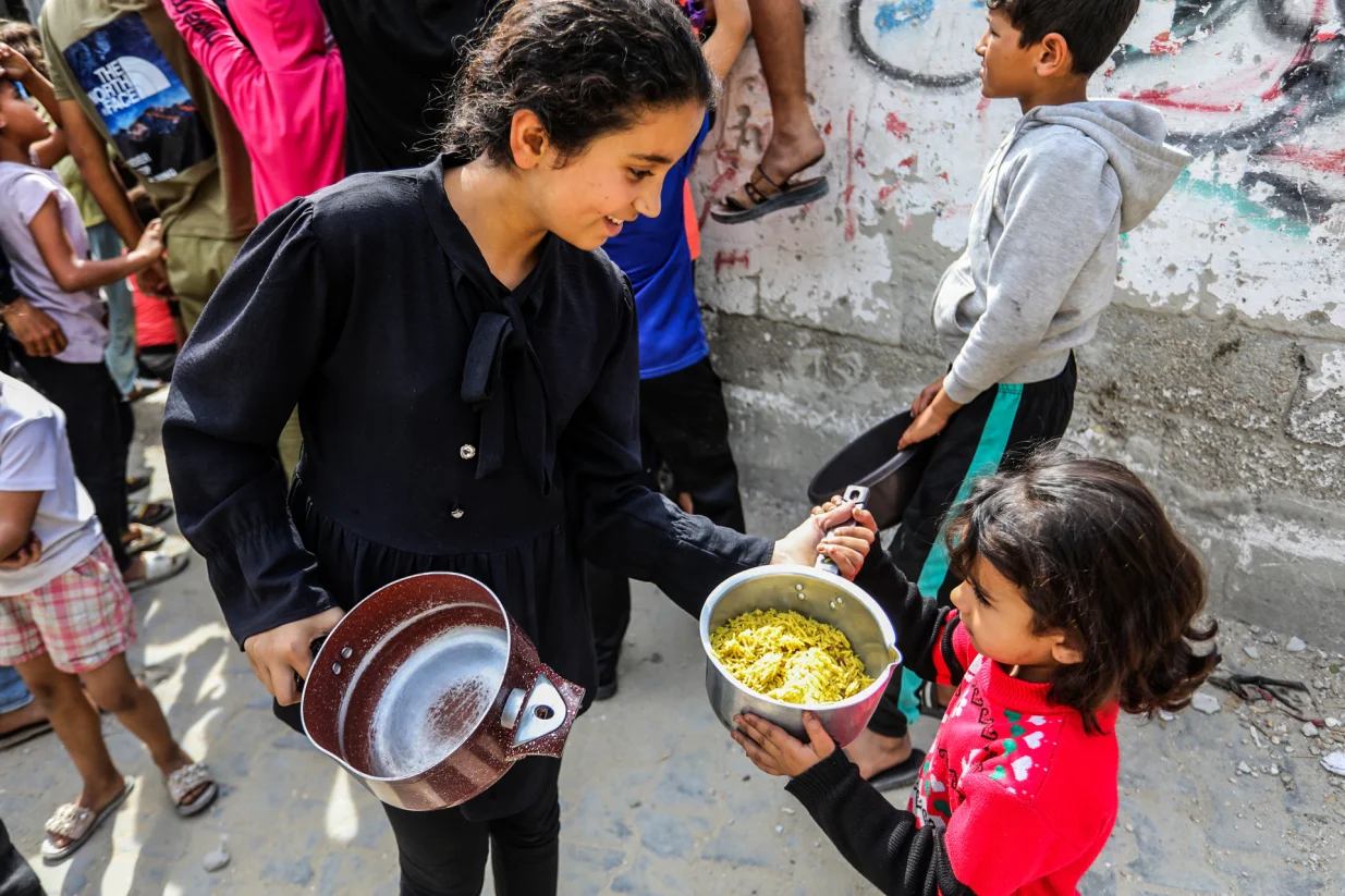 Khan Younis, Gaza - 6. maj 2025:Raseljeni Palestinci, ukljuДЌujuД‡i djecu, okupljaju se kako bi primili tople obroke koje distribuiraju dobrotvorne organizacije u Khan Yunisu, na jugu Gaze, 6. maja 2025. godine. Podjela hrane dogaД'a se usred izraelskih napada i blokade, koji su doveli do produbljivanja humanitarne krize u Pojasu Gaze (Abed Rahim Khatib - Anadolu Agency)/