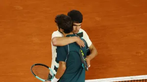 Tennis - French Open - Roland Garros, Paris, France - June 6, 2025 Italy's Lorenzo Musetti hugs Spain's Carlos Alcaraz as he walks off the court after retiring from the semi final match REUTERS/Lisi Niesner